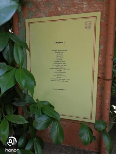 a sign on a brick wall with a plant at HOME L'UPUPA AMIATA in Salaiola