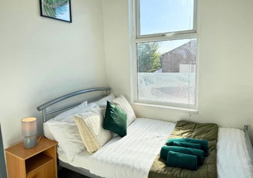 ein kleines Schlafzimmer mit einem Bett und einem Fenster in der Unterkunft Cosy 2 Bed Apt For Families With Free Parking in Liverpool