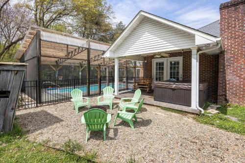 a patio with green chairs and a swimming pool at Private Farmhouse with Hot Tub in Dandridge