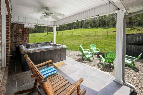 a patio with a hot tub and lawn chairs at Private Farmhouse with Hot Tub in Dandridge
