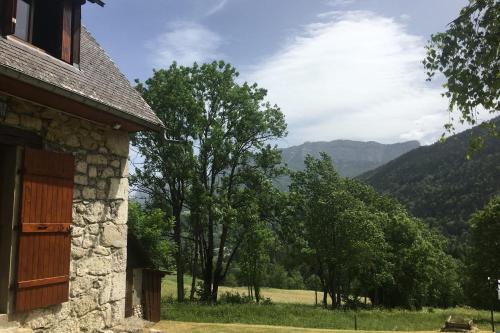 a stone building with a view of trees and mountains at Maison bucolique en Chartreuse in Chenevey