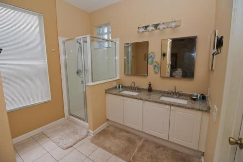 a bathroom with two sinks and a shower at Luxury Villa Private Pool And Great Game Room in Kissimmee