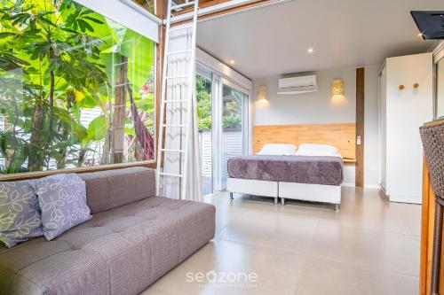 a bedroom with a bed and a couch at VGZ - Cabanas charmosas entre Barra de Ibiraquera e Rosa in Imbituba