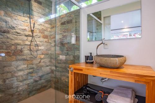 a bathroom with a sink and a glass shower at VGZ - Cabanas charmosas entre Barra de Ibiraquera e Rosa in Imbituba