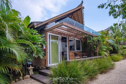 a small house with glass doors and trees at VGZ - Cabanas charmosas entre Barra de Ibiraquera e Rosa in Imbituba