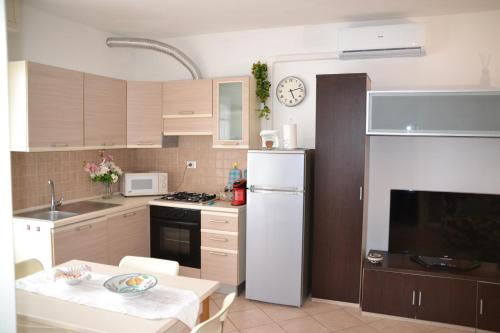 a kitchen with a white refrigerator and a table at Casa Rosina + box per auto 2 bici 1,5km dalle mura in Lucca