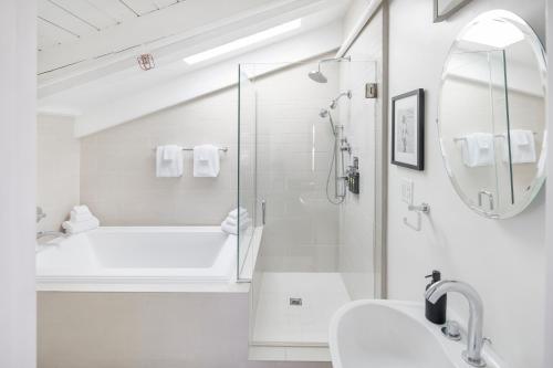 a white bathroom with a shower and a sink at Hotel Erwin Venice Beach in Los Angeles