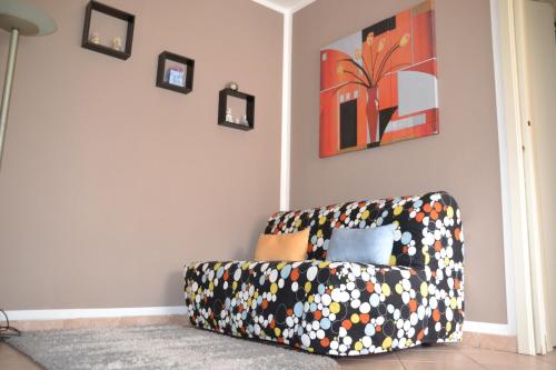 a couch sitting in a living room with pictures on the wall at Casa Rosina + box per auto 2 bici 1,5km dalle mura in Lucca