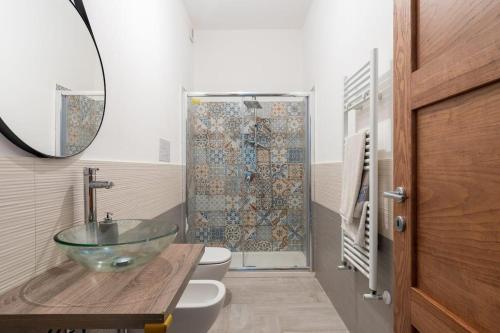 La salle de bains est pourvue d'un lavabo en verre et d'une douche. dans l'établissement Villablanca, à Terrasini