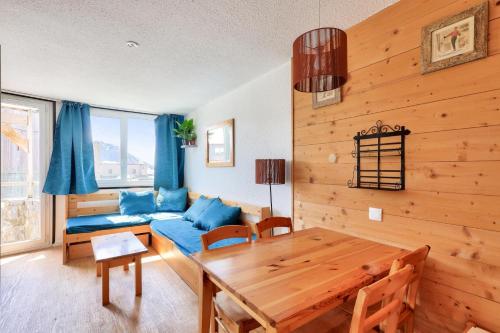un salon avec un canapé bleu et une table dans l'établissement Résidence Les Alpages - maeva Home - Appartement 2 pièces 5 personnes - Sélection MAE-2944, à Morzine