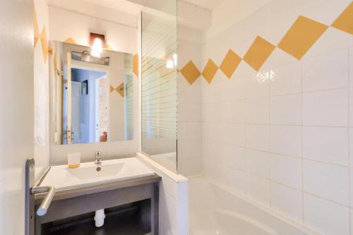 une salle de bain avec un lavabo, une baignoire et un miroir dans l'établissement Résidence Les Alpages - maeva Home - Appartement 2 pièces 5 personnes - Sélection MAE-2944, à Morzine