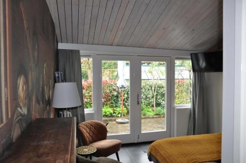 a bedroom with a bed and a sliding glass door at B&B Slotstraat in Dreischor