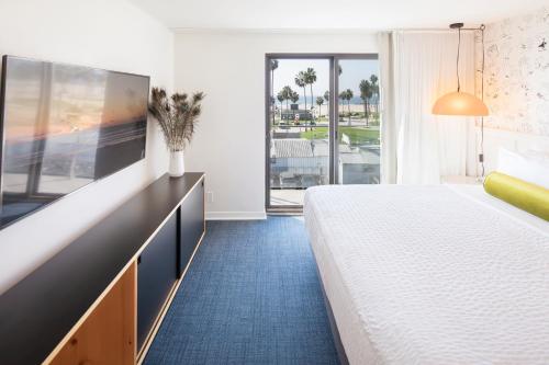 ein Hotelzimmer mit einem großen Bett und einem großen Fenster in der Unterkunft Hotel Erwin Venice Beach in Los Angeles