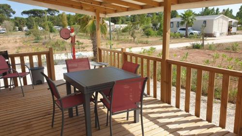 patio con tavolo e sedie su una terrazza di Camping Les Pins maritimes a Hyères