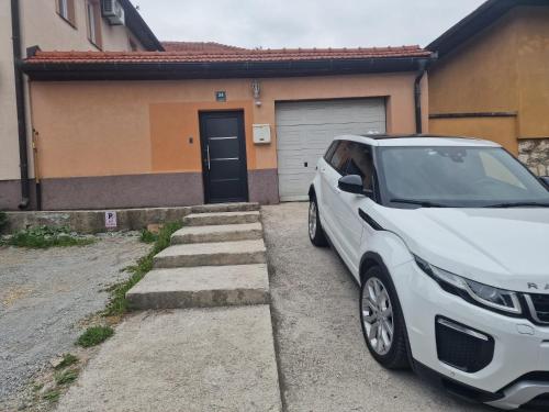 a white car parked in front of a house at Apartment Irma in Sarajevo