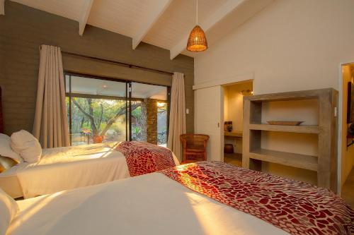1 Schlafzimmer mit 2 Betten und einem Fenster in der Unterkunft Kaja Noko in Marloth Park