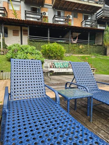 two blue chairs and a table on a patio at Pousada Vale das Flores in Nova Friburgo