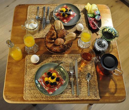 une table avec des assiettes de nourriture et des verres de jus d'orange dans l'établissement B&B Slotstraat, à Dreischor