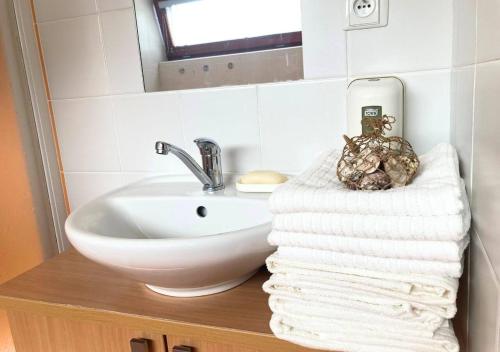 a bathroom with a sink and a pile of towels at Apartmán na Valašsku in Horní Bečva