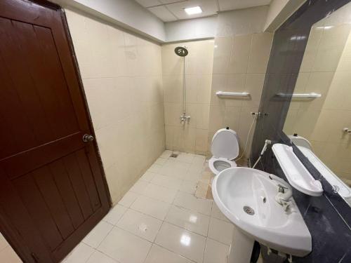 a bathroom with a sink and a toilet anditerator at Serene Private Room in Karachi