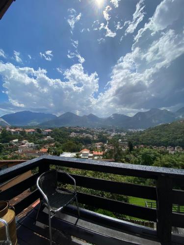 a bench on a balcony with a view of the mountains at Pousada Vale das Flores in Nova Friburgo