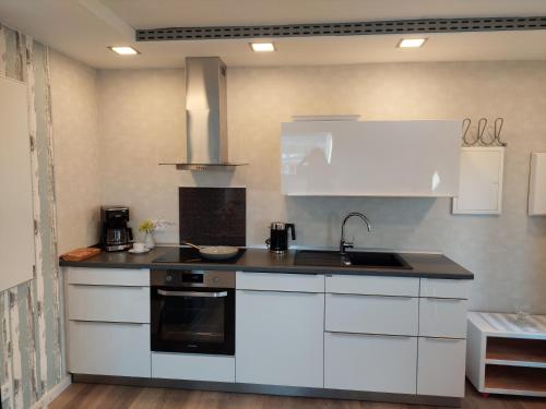 a kitchen with white cabinets and a sink at auszeit34 in Ebelsbach