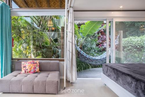 a living room with a couch and a large window at VGZ - Cabanas charmosas entre Barra de Ibiraquera e Rosa in Imbituba