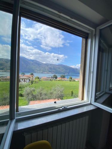 a window with a view of a field at 2 Cuori al Lago - Appartamento in villetta singola in Mandello del Lario