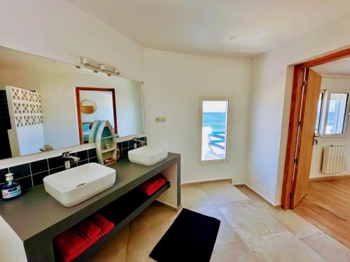 uma casa de banho com um lavatório e um espelho em Villa vue imprenable sur l’Océan. em Moulay Bousselham