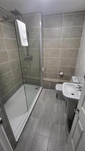 a bathroom with a shower and a toilet and a sink at Nysdill Accommodation Ltd in Norwich
