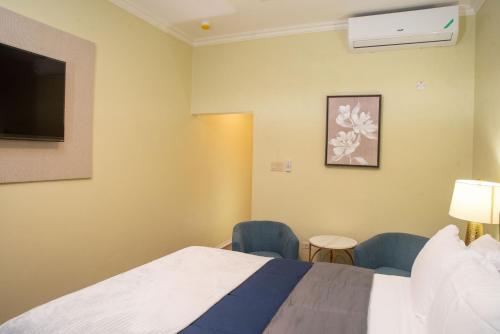 a hotel room with a bed and two chairs at Sky's Villa Resort in Buff Bay