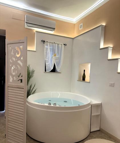 a white bathroom with a tub in a room at Agri Resort Masusa in Aquara