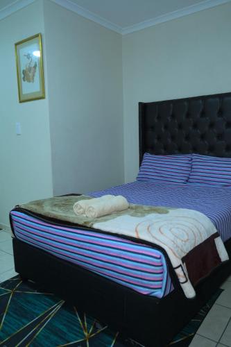 a bedroom with a bed with a blue and purple at SUPA Lodge in Parow
