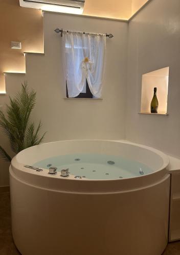 a large bath tub in a room with a window at Agri Resort Masusa in Aquara