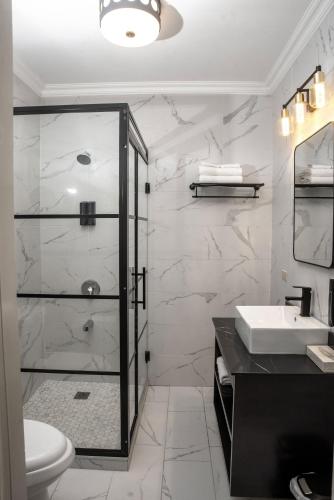 a bathroom with a shower and a toilet and a sink at Sky's Villa Resort in Buff Bay