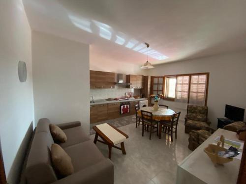 ein Wohnzimmer mit einem Sofa und einem Tisch in der Unterkunft CASA SANT'ANNA in SantʼAnna Arresi
