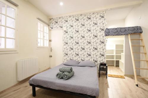 1 dormitorio con cama y pared en Charmant & Cosy - Centre historique Ecusson, en Montpellier
