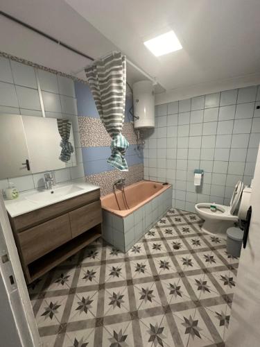 ein Badezimmer mit einer Badewanne, einem Waschbecken und einem WC in der Unterkunft Nancy & Vaggelis Holiday Studios in Litochoro
