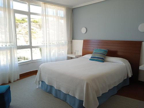 Hotel Sablón في يانس: غرفة نوم بسرير ونافذة كبيرة