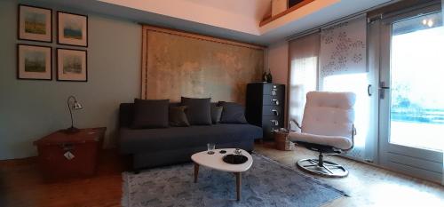 a living room with a couch and a table at Tuinhuis In je Element in Hoogeveen