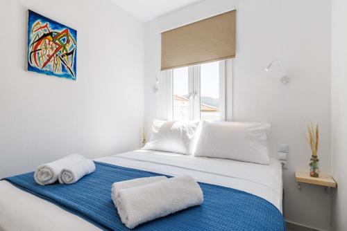 a bedroom with a bed with towels on it at House Victoria in Skopelos Town