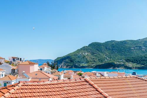 a view of a town with red roofs and the water at Victoria House in Skopelos Town