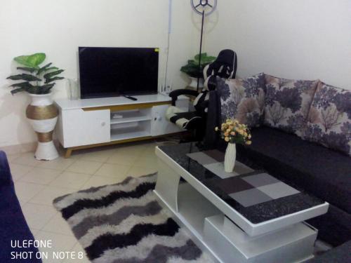 a living room with a couch and a tv at Top tier A 01 in Nakuru
