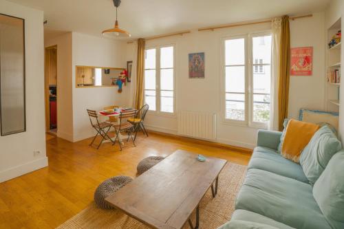 un salon avec un canapé et une table dans l'établissement L'Opaline ~ T2 Calme ~ Proche Métro Idéal pour JO, à Paris