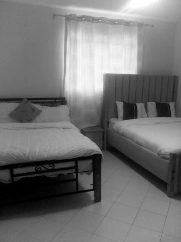 a bedroom with two beds and a window at Top tier A 01 in Nakuru