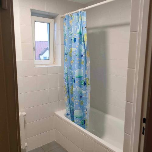 łazienka z zasłoną prysznicową i wanną w obiekcie Pokoje noclegowe w mieście Grajewo