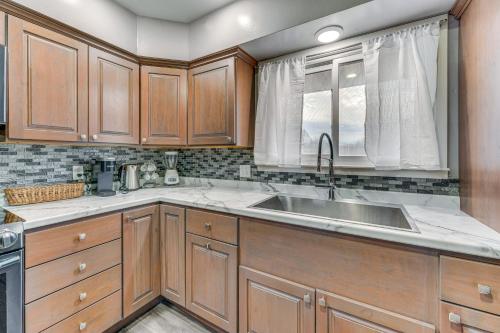 Una cocina con gabinetes de madera y un fregadero. en Newly Remodeled Home in Storm Lake with Private Yard, en Storm Lake