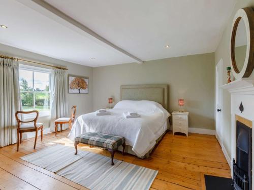 a bedroom with a white bed and a fireplace at 3 Bed in Saffron Walden 85662 in Finchingfield