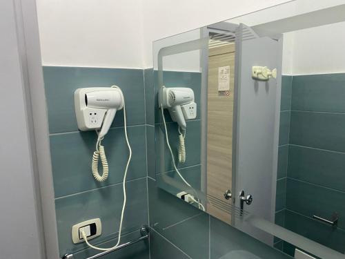 bagno con specchio e telefono appeso al muro di MDP Hotel a Cervia