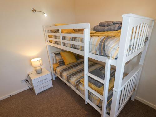 a bedroom with two bunk beds and a lamp at Hillview in Colwyn Bay